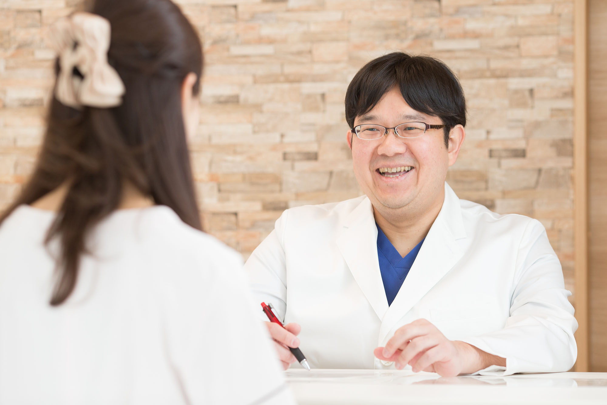患者様の相談に笑顔で応える院長大久保拓馬