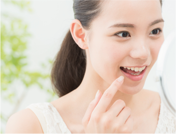 女性が白い歯を鏡で見ている画像